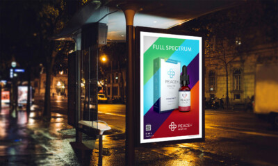 Billboard for Peace+ displaying Full Spectrum CBD products at a city bus stop at night.