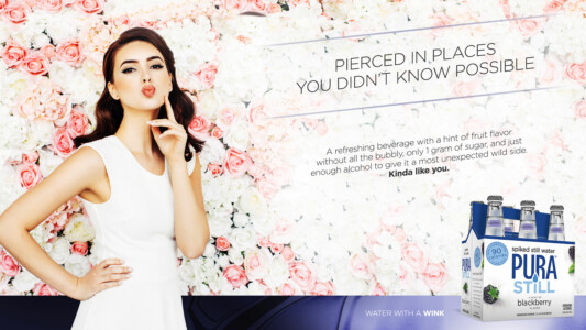 Model poses playfully against a floral backdrop, promoting Pura Still blackberry water with a catchy tagline.