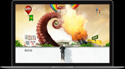 A colorful game interface featuring an octopus, explosion, and Skittles branding on a laptop screen.