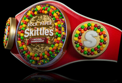 Colorful championship belt decorated with Skittles and the text "Rock Paper Skittles National Championship.